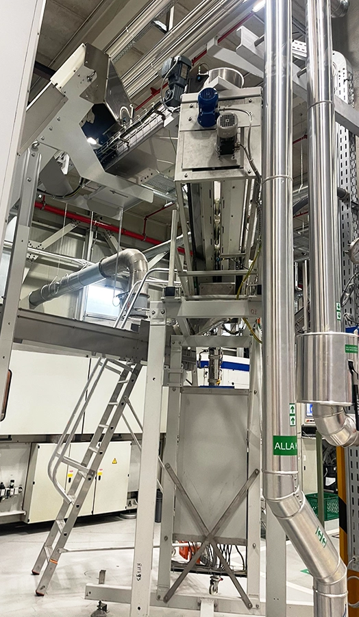 Macchinario industriale con sistema di carico e tubazioni per processo produttivo