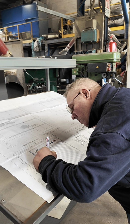 Tecnico COIM al lavoro su disegno tecnico di impianto industriale