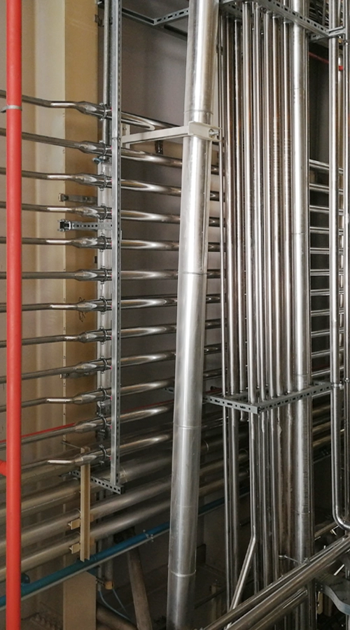 Collettore di distribuzione con tubazioni in acciaio inox in impianto industriale COIM 2005