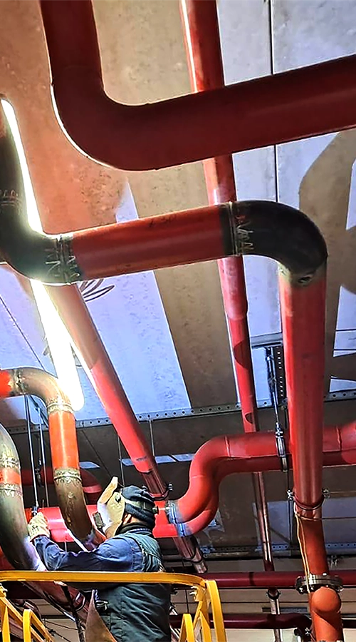 Operatore impegnato nella saldatura delle tubazioni di un impianto Black Utilities.